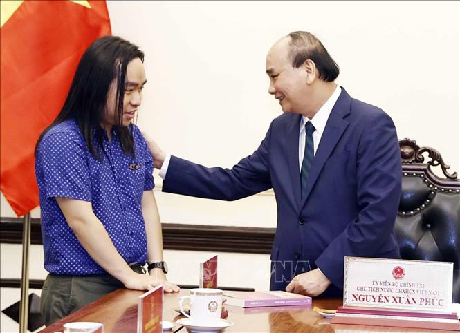 Chủ tịch nước Nguyễn Xuân Phúc gặp tài năng văn học trẻ Nguyễn Bình. Ảnh: Thống Nhất – TTXVN

