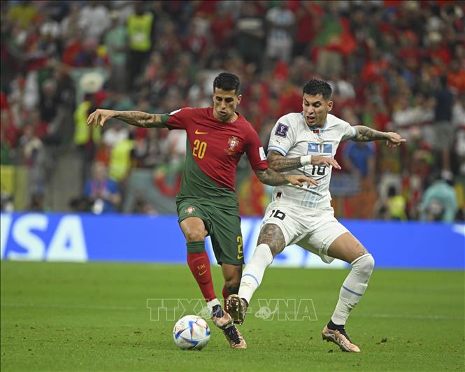 Cầu thủ Bồ Đào Nha Joao Cancelo (trái) tranh bóng với Mathias Olivera của Uruguay. Ảnh: THX/TTXVN