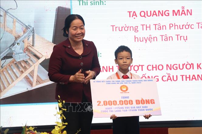 Phó Giám đốc Sở Giáo dục và Đào tạo Long An cô Phan Thị Dạ Thảo trao học bổng cho em Tạ Quang Mẫn. Ảnh: Đức Hạnh - TTXVN 