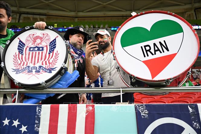 Cổ động viên Mỹ và Iran chụp ảnh chung trước trận đấu. Ảnh: AFP/ TTXVN