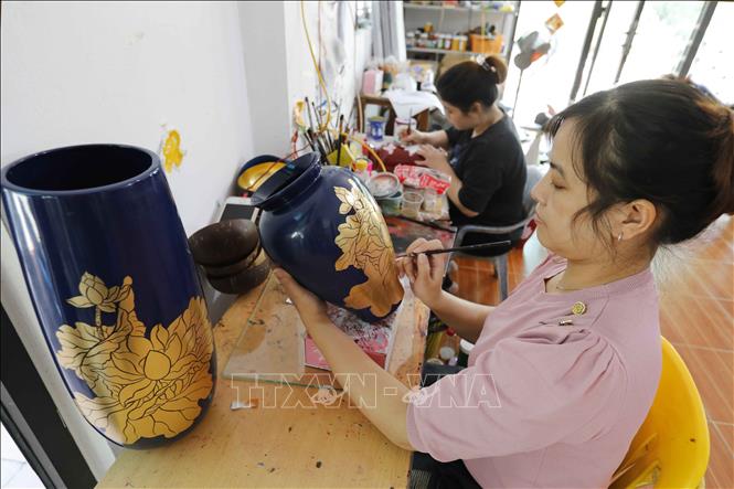 Vẽ hoa văn trên sản phẩm gốm sứ tại cơ sở Nguyễn Tiến Công, làng nghề Hạ Thái. Ảnh: Trần Việt - TTXVN