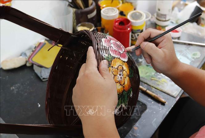  Vẽ hoa văn trên sản phẩm mây tre đan tại cơ sở Nguyễn Tiến Công, làng nghề Hạ Thái. Ảnh: Trần Việt - TTXVN