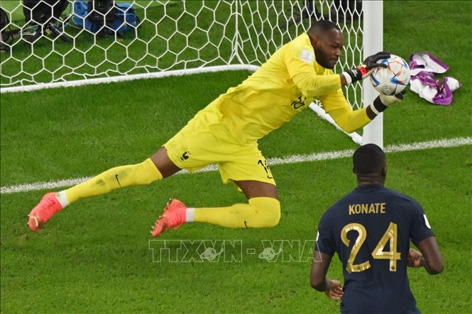 Thủ thành Pháp Steve Mandanda đổ người cản phá cú sút xa hiểm hóc của cầu thủ Tunisia. Ảnh: AFP/TTXVN
