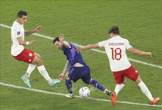 Tiền đạo Argentina Lionel Messi (giữa) nỗ lực đi bóng trước sự cản phá của các cầu thủ Ba Lan. Ảnh: THX/TTXVN