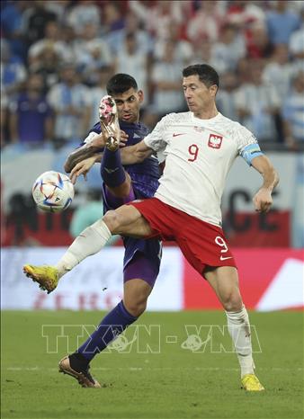 Tiền đạo Ba Lan Robert Lewandowski (phải) tranh bóng với tuyển thủ Argentina Cristian Romero. Ảnh: THX/TTXVN