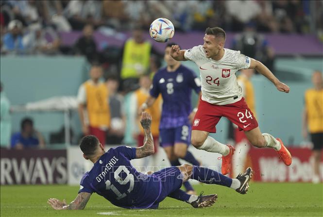 Tiền vệ Ba Lan Przemyslaw Frankowski (số 24) trong pha tranh bóng với tuyển thủ Argentina Nicolas Otamendi (số 19). Ảnh: THX/TTXVN