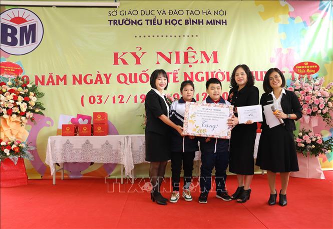 Thứ trưởng Bộ Giáo dục và Đào tạo Ngô Thị Minh (thứ 2 từ phải sang) tặng 20 suất học bổng cho học sinh trường Tiểu học Bình Minh. Ảnh: Hoàng Hiếu - TTXVN 
