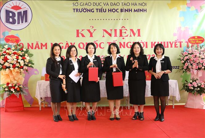 Thứ trưởng Bộ Giáo dục và Đào tạo Ngô Thị Minh tặng quà cán bộ, giáo viên, nhân viên trường Tiểu học Bình Minh. Ảnh: Hoàng Hiếu - TTXVN