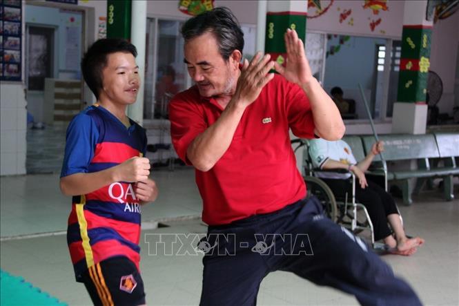Võ sư Hà Trọng Khánh (Trung tâm huấn luyện võ thuật cho trẻ mồ côi và khuyết tật tại Thành phố Hồ Chí Minh) hướng dẫn các thế võ cho trẻ khuyết tật. Ảnh: Xuân Dự - TTXVN