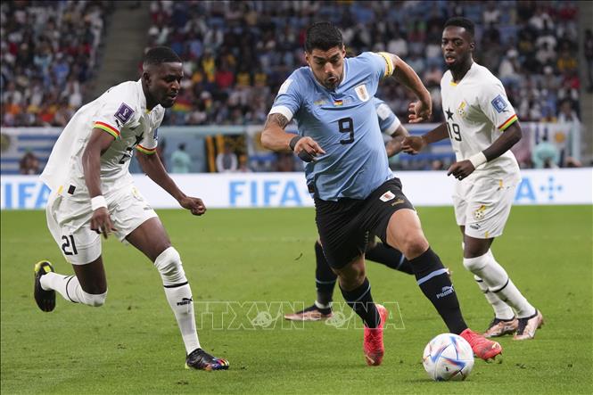 Luis Suarez (giữa) của Uruguay nỗ lực khống chế bóng trước các cầu thủ Ghana. Ảnh: THX/TTXVN