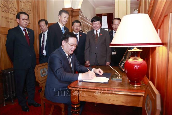 National Assembly Chairman Vuong Dinh Hue signs in the memorial book at the Government House in Wellington on December 5. VNA Photo: Doãn Tấn