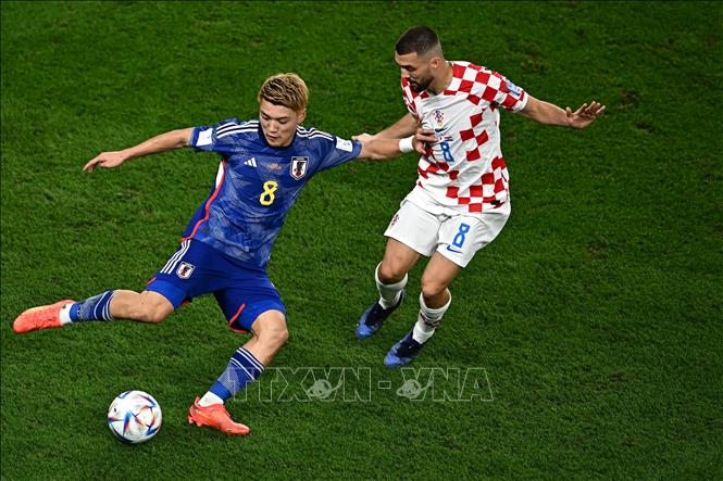Ritsu Doan (trái) của Nhật Bản đi bóng trước sự đeo bám của cầu thủ Croatia Mateo Kovacic. Ảnh: AFP/TTXVN