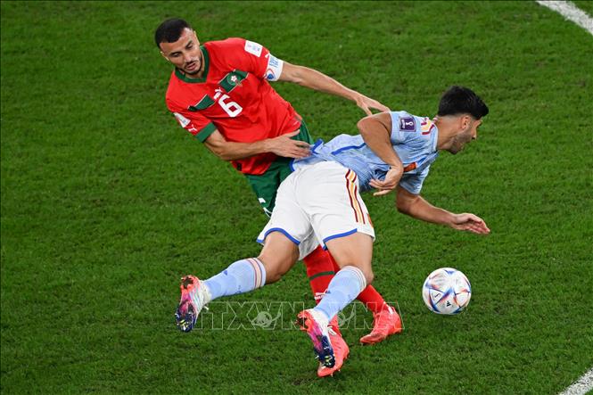 Pha tranh bóng bổng giữa cầu thủ Marco Asensio (phải) tuyển Tây Ban Nha và Romain Saiss tuyển Maroc. Ảnh: THX/ TTXVN