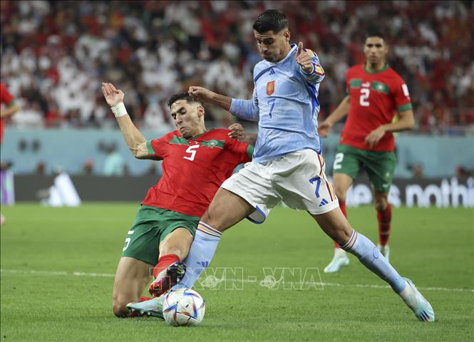 Pha tranh bóng quyết liệt giữa cầu thủ Nayef Aguerd (trái) tuyển Maroc và Alvaro Morata tuyển Tây Ban Nha. Ảnh: THX/ TTXVN