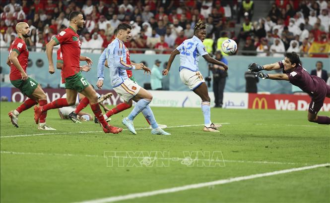 Dani Olmo treo bóng từ chấm đá phạt chếch bên cánh trái vào góc xa, thủ môn Yassine Bounou (phải) kịp thời đổ người đẩy bóng cứu thua cho Maroc. Ảnh: THX/ TTXVN