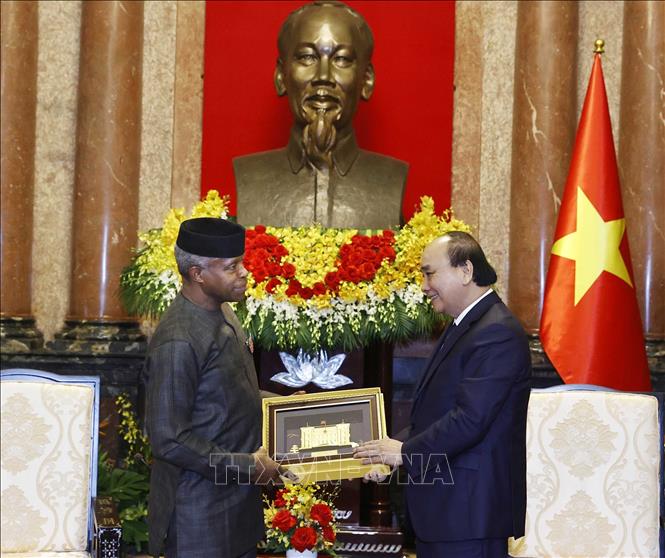 Chủ tịch nước Nguyễn Xuân Phúc tặng quà lưu niệm cho Phó Tổng thống CHLB Nigeria Yemi Osinbajo. Ảnh: Thống Nhất- TTXVN