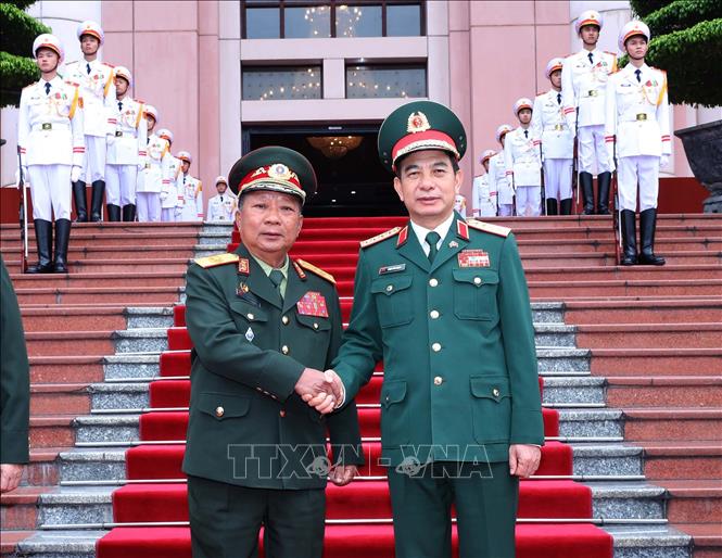 Bộ trưởng Bộ Quốc phòng Phan Văn Giang và Phó Thủ tướng, Bộ trưởng Quốc phòng Lào Chansamone Chanyalath tại lễ đón. Ảnh: Trọng Đức - TTXVN