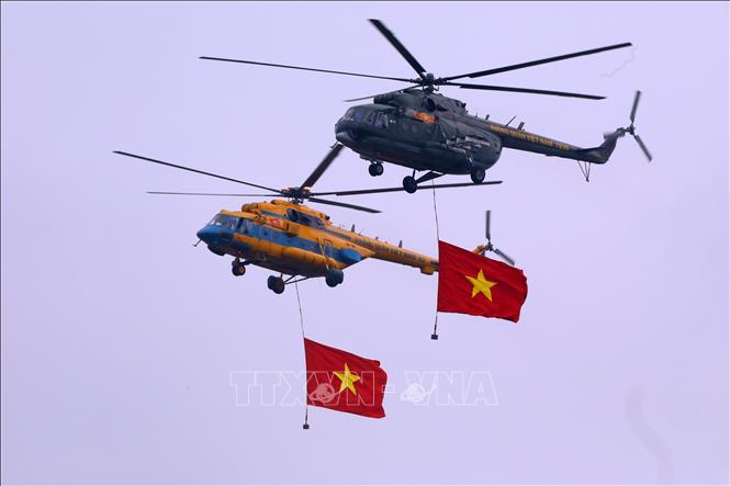 Biên đội trực thăng dòng Mi thuộc Trung đoàn không quân 916 cùng cờ Tổ quốc biểu diễn trên không gian triển lãm. Ảnh: Văn Điệp - TTXVN