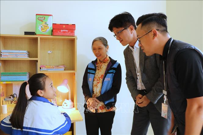 Ông Park Young Dall, Giám đốc khối Hành chính nhân sự LG Display trò chuyện với mẹ con em Nguyễn Thị Hiền trong ngôi nhà mới. Ảnh: Minh Thu - TTXVN