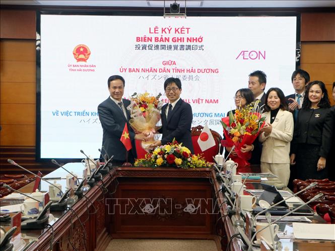 Chủ tịch UBND tỉnh Hải Dương Triệu Thế Hùng (bên trái) tặng hoa chúc mừng đại diện Công ty TNHH AEONMALL Việt Nam. Ảnh: Mạnh Tú - TTXVN