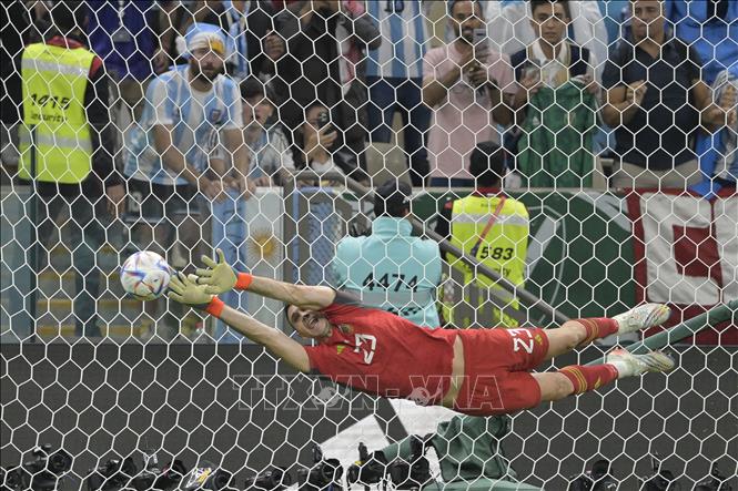 Thủ thành Argentina Emiliano Martinez đẩy thành công quả sút penalty đầu tiên của đội trưởng Hà Lan Van Dijk. Ảnh: AFP/TTXVN
