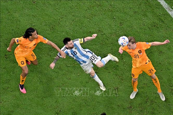 Tiền đạo Argentina Lionel Messi (giữa) đi bóng trong sự truy cản quyết liệt của các tuyển thủ Hà Lan. Ảnh: AFP/TTXVN