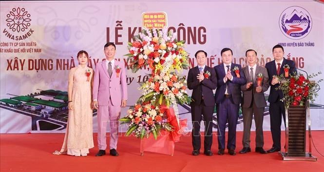 Lãnh đạo tỉnh Lào Cai tặng hoa chúc mừng Công ty Cổ phần Sản xuất và Xuất khẩu quế hồi Việt Nam. Ảnh: Hương Thu - TTXVN
