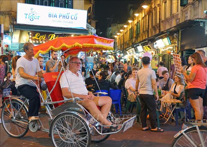 Ngồi trên xích lô, hít thở khí trời trong lành, chậm rãi di chuyển qua từng con phố, ngõ hẻm để ngắm trọn những nét văn hóa, hoạt động đời sống thường ngày của người dân Thủ đô đã mang lại những ấn tượng khó phai đối với nhiều du khách quốc tế. Ảnh: Khánh Hòa – TTXVN 
