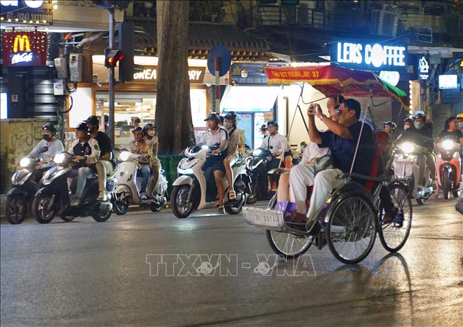 Du khách trải nghiệm du lịch bằng xích lô trên phố Tràng Tiền. Ảnh: Khánh Hòa - TTXVN 