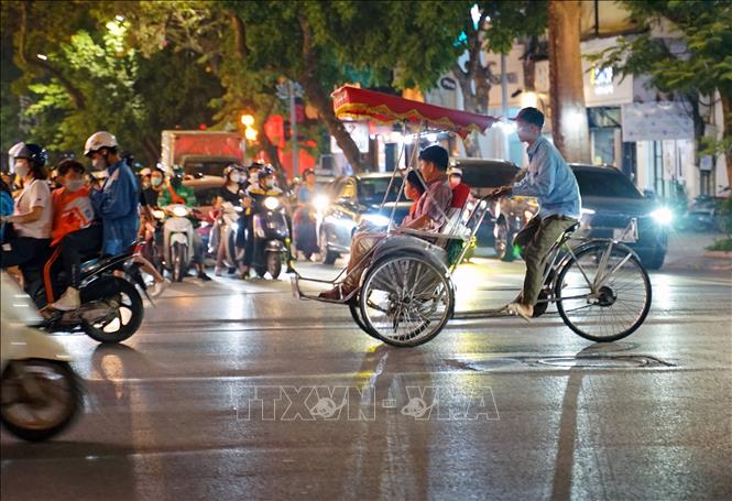 Du khách trải nghiệm du lịch bằng xích lô trên phố Tràng Tiền. Ảnh: Khánh Hòa - TTXVN 