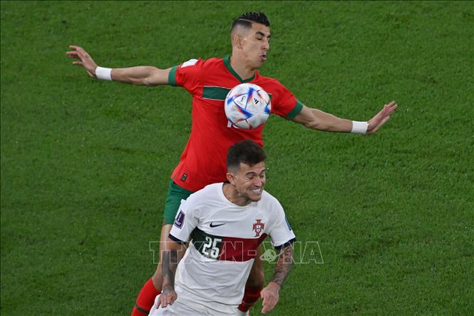 Hai đội thi đấu rất quyết liệt, không ngại va chạm. Bồ Đào Nha đang kiểm soát bóng tốt hơn, nhưng Maroc lại phòng ngự chặt chẽ. Trong ảnh: Pha tranh bóng giữa tiền vệ Bồ Đào Nha Otavio (phía dưới) và hậu vệ Maroc Jawad El Yamiq. Ảnh: AFP/ TTXVN