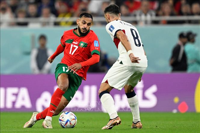 Tiền vệ Maroc Sofiane Boufal (trái) thực hiện cú dứt điểm từ ngoài vòng cấm, nhưng bóng đi không thực sự hiểm hóc nên bị thủ môn Bồ Đào Nha Diogo Meireles Costa ôm gọn. Ảnh: AFP/ TTXVN
