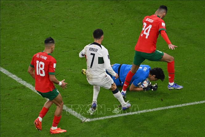 Tiền đạo Bồ Đào Nha Ronaldo (số 7) bứt tốc nhận đường chuyền của đồng đội sau đó dứt điểm rất căng, nhưng thủ môn Yassine Bounou của Maroc một lần nữa lại cứu thua xuất sắc. Ảnh: AFP/ TTXVN
