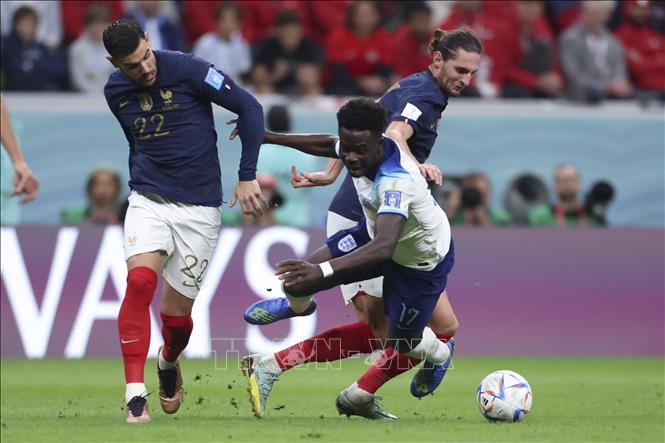 Bukayo Saka (số 17) của Anh đi bóng trong sự đeo bám quyết liệt của các tuyển thủ Pháp Theo Hernandez (số 22) và Adrien Rabiot. Ảnh: THX/TTXVN