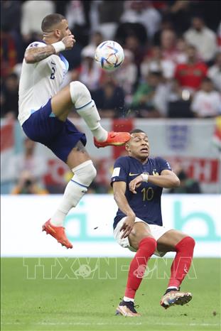 Tiền đạo Pháp Kylian Mbappe (phải) nỗ lực tranh bóng với tuyển thủ Kyle Walker của Anh. Ảnh: THX/TTXVN