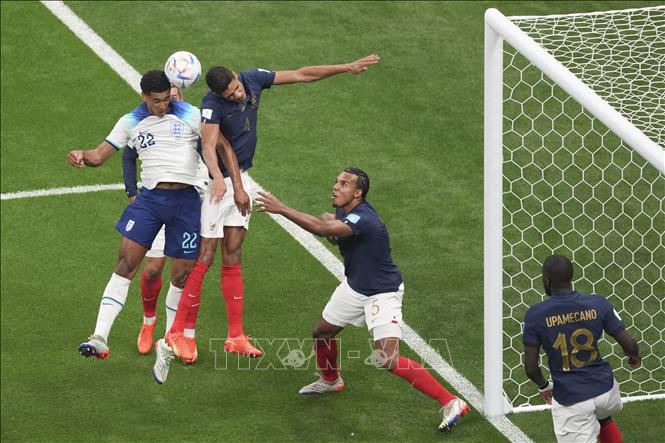 Pha tranh bóng bổng giữa Jude Bellingham (thứ nhất, trái) của Anh với Raphael Varane của Pháp. Ảnh: THX/TTXVN
