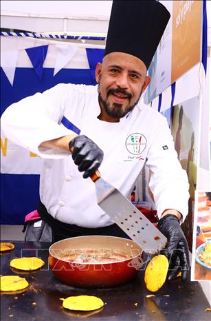 A cook from El Salvador makes his country’s famous food. VNA Photo: Lâm Khánh
