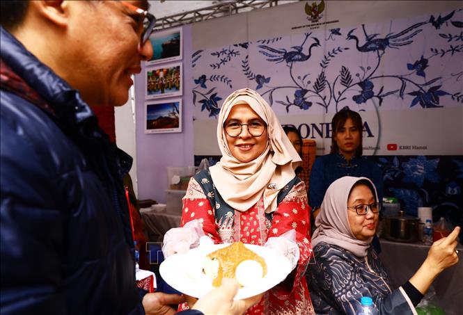 An Indonesian woman introduces her country’s food. VNA Photo: Lâm Khánh

