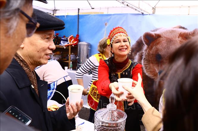 A Russian woman introduces her country’s drink. VNA Photo: Lâm Khánh
