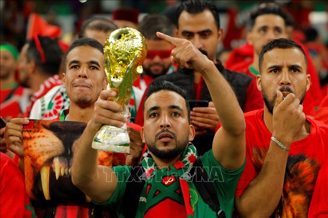 Trong ảnh: Các cổ động viên Maroc cổ vũ cho đội nhà trong trận gặp Bồ Đào Nha ở Doha, Qatar, ngày 10/12/2022. Ảnh: AFP/TTXVN