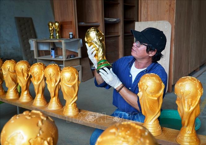Trong ảnh: Anh Văn Tám trực tiếp làm “Cúp Vàng FIFA” để thỏa niềm đam mê bóng đá của mình và bán cho người hâm mộ. Ảnh: Hồng Đạt - TTXVN
