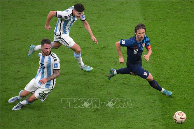 Tiền đạo Croatia Luka Modric (phải) đi bóng qua các tiền vệ Argentina Alexis Mac Allister (số 20) và Julian Alvarez (số 9). Ảnh: AFP/TTXVN