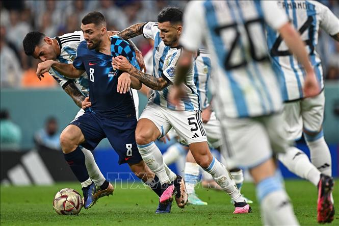 Hậu vệ Cristian Romero (trái) của Argentina cản đường đi bóng của tiền vệ Croatia Mateo Kovacic (giữa). Ảnh: AFP/TTXVN