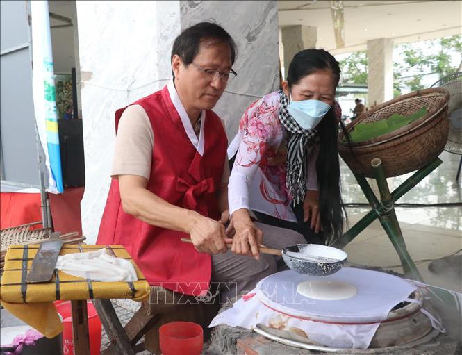 Trong ảnh: Đại biểu người Hàn Quốc trải nghiệm làm bánh tráng Mỹ Lồng - đặc sản Bến Tre. Ảnh: Chương Đài - TTXVN