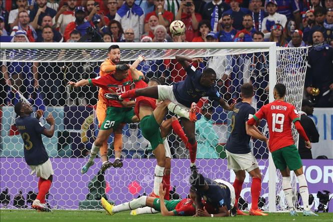 Pha tranh bóng bổng gay cấn buộc thủ thành Pháp Hugo Lloris phải nhảy cao phá bóng trước các tuyển thủ Maroc. Ảnh: AFP/TTXVN