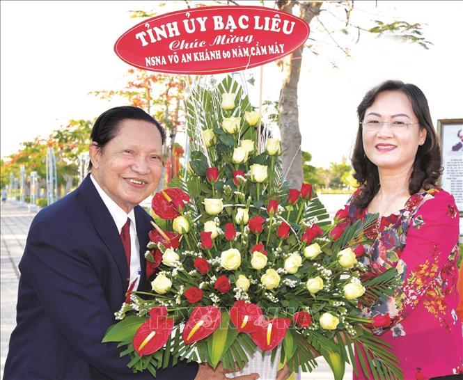 Phó Bí thư Tỉnh ủy Bạc Liêu Lê Thị Ái Nam tặng hoa cho Nhà báo - Nghệ sĩ nhiếp ảnh Võ An Khánh. Ảnh: TTXVN phát