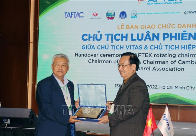 Chairman of the Vietnam Textile and Apparel Association (VITAS) Vu Duc Giang hands over the rotating presidency of AFTEX for 2023 - 2024 to Tan Kim Teck Albert, Chairman of the Textile, Apparel, Footwear and Travel Goods Association in Cambodia. VNA Photo: Mỹ Phương