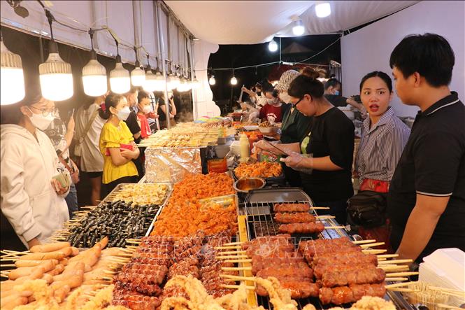 Những món ăn nhanh đường phố thu hút khách quan tâm. Ảnh: Chí Tưởng -TTXVN