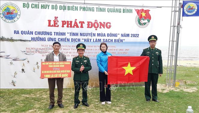 Thượng tá Ngô Minh Điền, Phó Chính ủy BĐBP Quảng Bình trao tặng 1.000 lá cờ Tổ quốc cho ngư dân xã Đức Trạch. Ảnh: Võ Dung - TTXVN