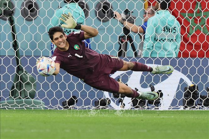 Thủ thành Maroc Yassine Bounou (số 1) đẩy thành công quả đá luân lưu của tiền vệ Tây Ban Nha Sergio Busquets trong trận đấu vòng 1/8 World Cup 2022. Ảnh: AFP/TTXVN